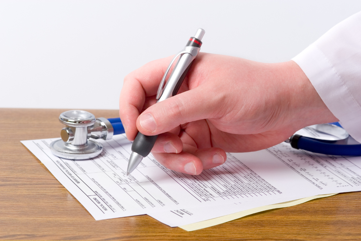 gros plan sur la main d'un vétérinaire qui remplit au stylo une fiche patient
